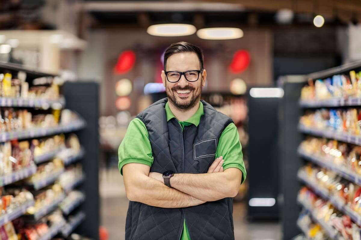 Smiling man standing in grocery store aisle